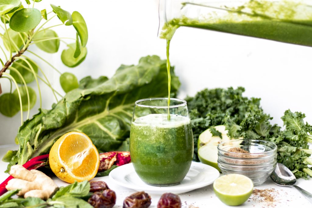 pouring a green smoothie from a blender 