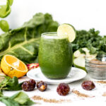 green smoothie surrounded by fresh fruit