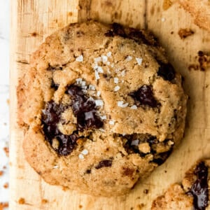 overhead shot of a vegan tahini chocolate chip cooking with puddles of dark chocolate and flaky sea salt