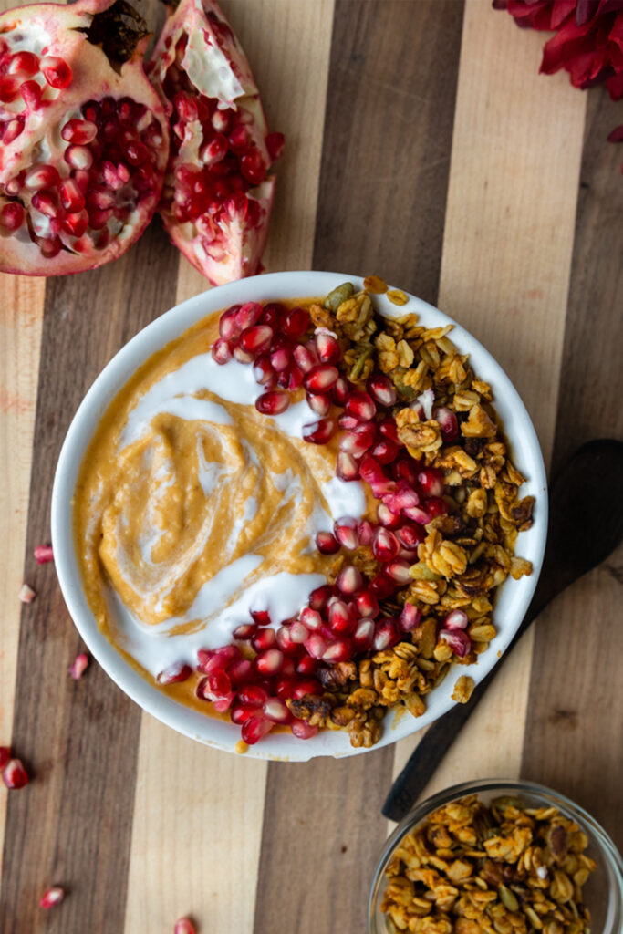 overhead shot of pumpkin pie smoothie bowl with pomegranate and granola
