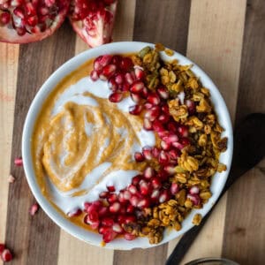 pumpkin pie smoothie with a spoon scooped out of it on a wood board