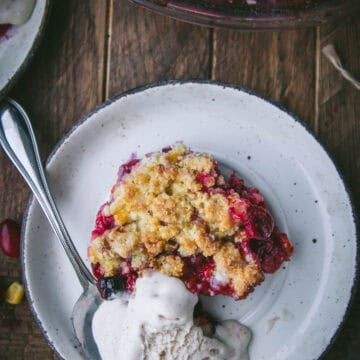 scoop of cranberry cornbread crisp on a plate with ice cream