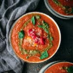 overhead shot of creamy vegan tomato soup with pesto swirls