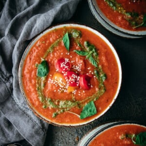 overhead shot of creamy vegan tomato soup with pesto swirls