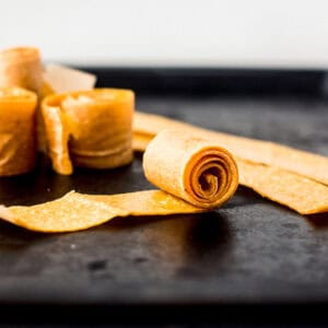 roll of mango fruit leather coiled on a black sheet