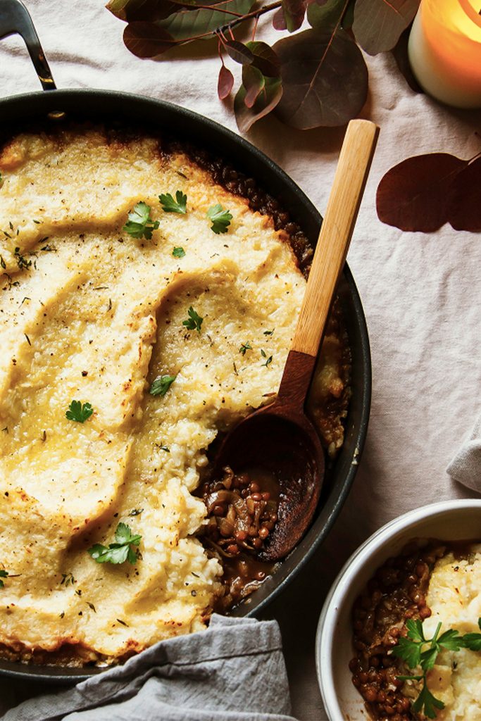 pot with lentil stew covered in creamy mashed potatoes on a tablecloth