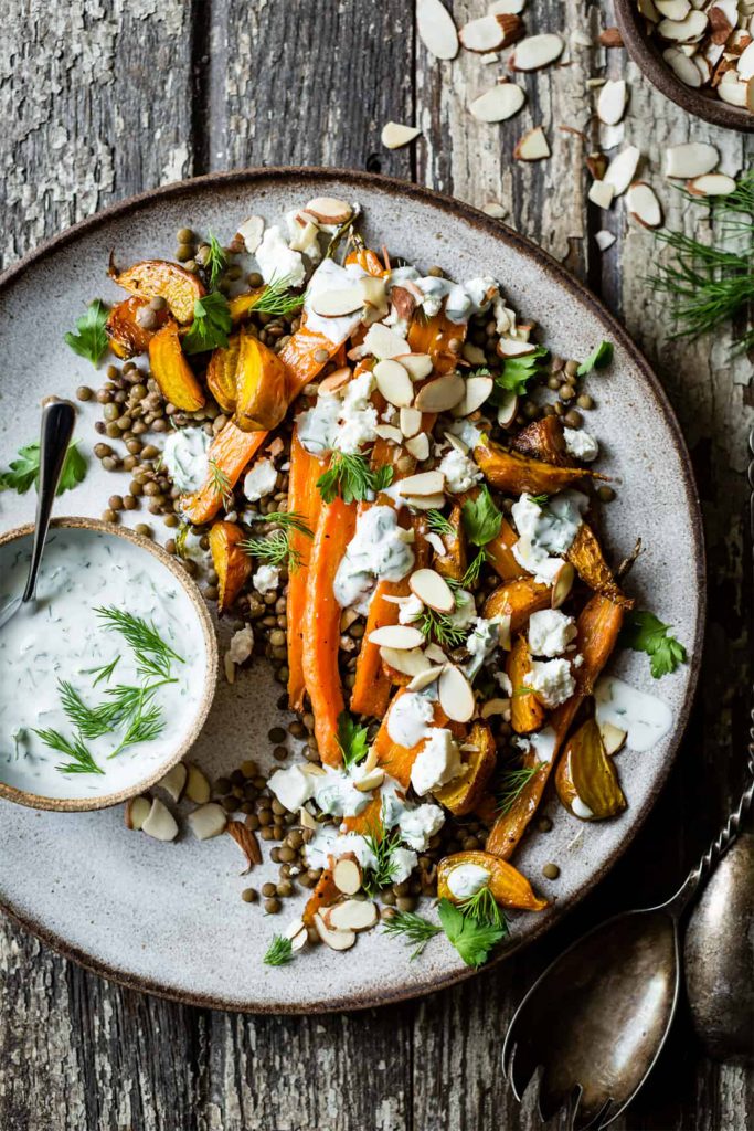 white plate with carrot salad on wooden board