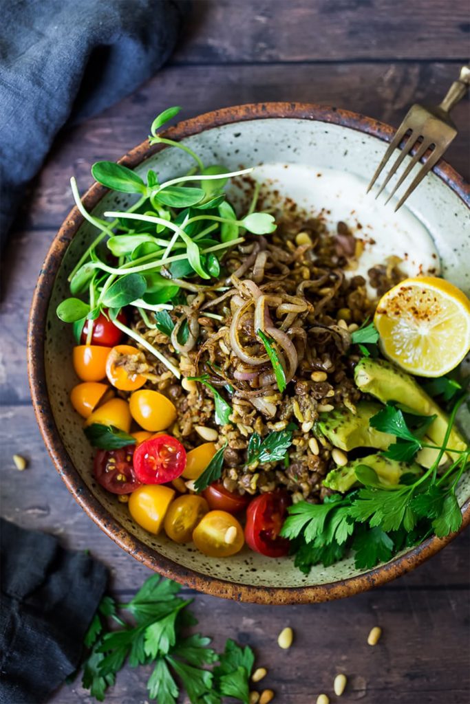 white bowl with salad, red tomatoes, and mujadara