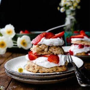 stack of vegan strawberry shortcake with whipped cream on a wooden table