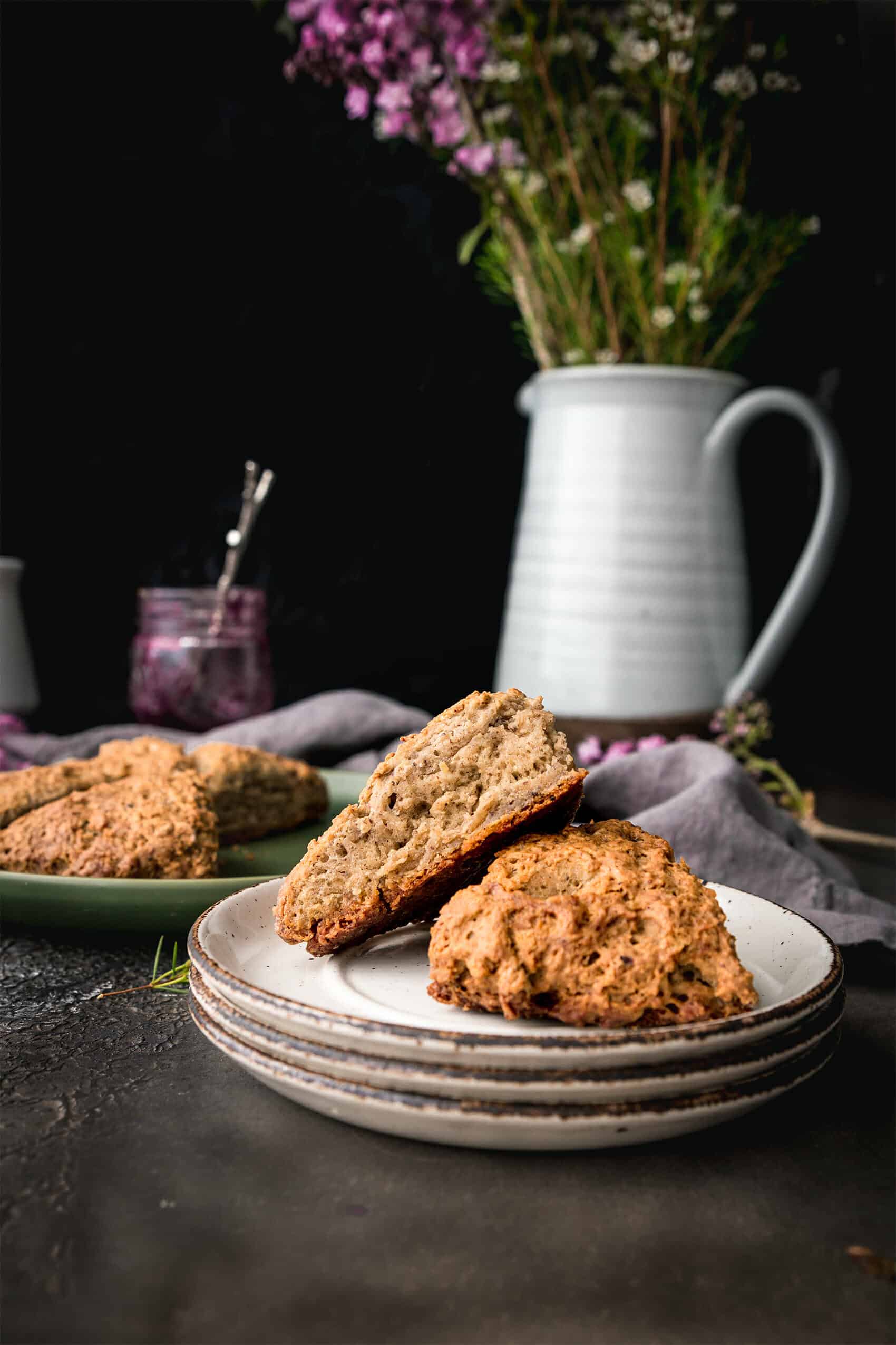 plate of two vegan scones next to a jar pf jam