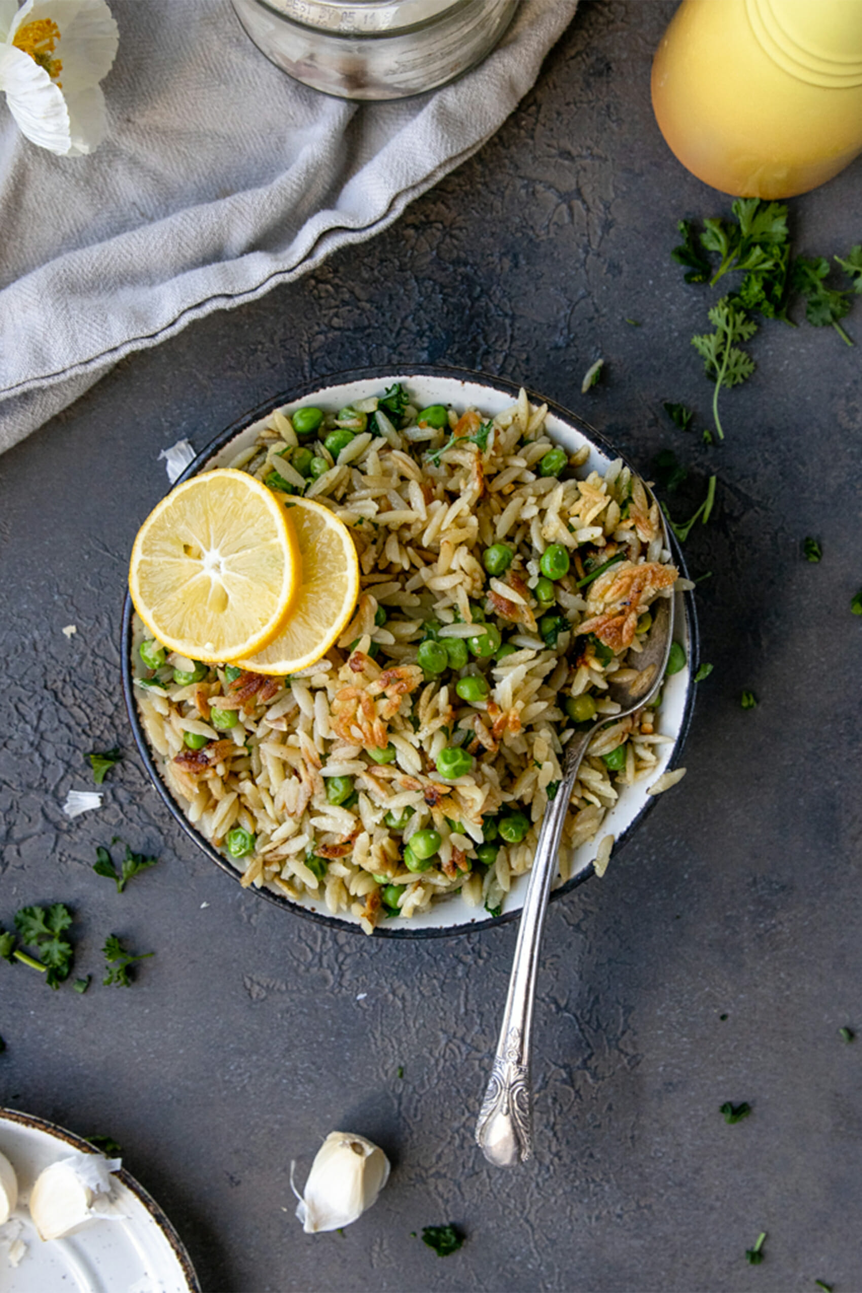 overhead shot of crispy orzo with peas and two lemon rounds