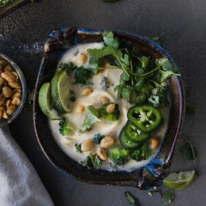 overhead shot of spicy peanut noodle soup with noodles and limes