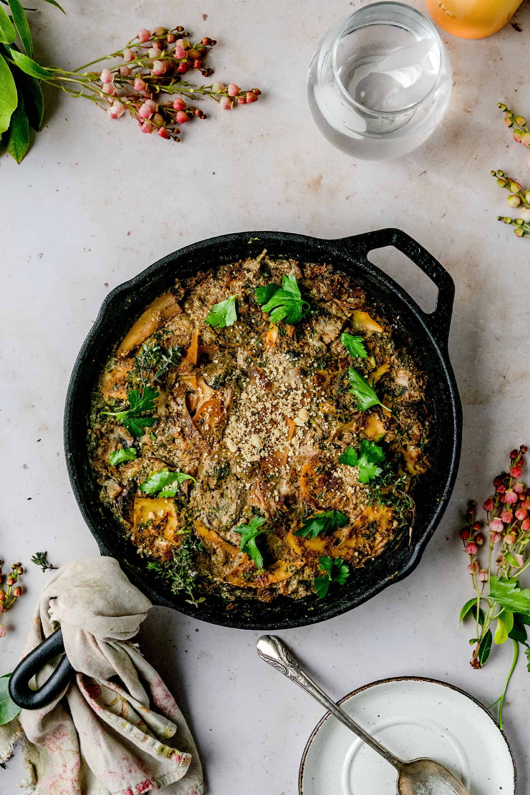 overhead shot of french onion skillet pasta bake on a marble board with a silver spoon