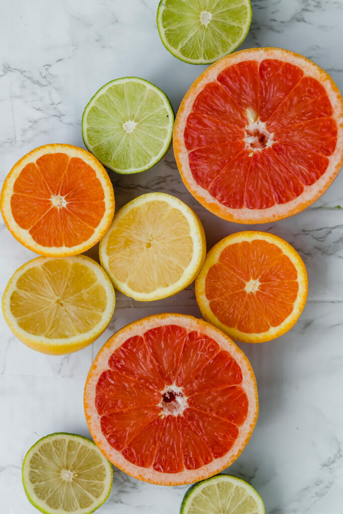 table of sliced lemons, limes, oranges, and grapefruit