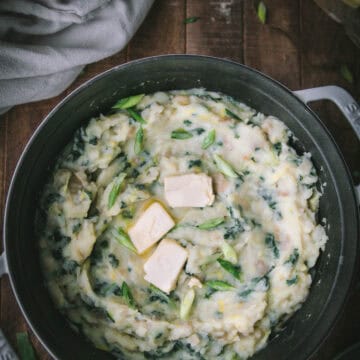 overhead shot of vegan colcannon in a white pot on a wooden table