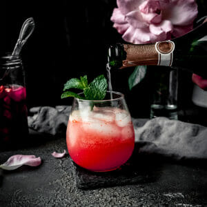 champagne pouring into a glass of sparkling rhubarb shrub