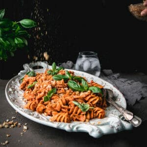 breadcrumbs sprinkled onto a plate of roasted red pepper pasta salad