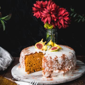 side view of vegan pumpkin cake on a tray topped with brown butter frosting