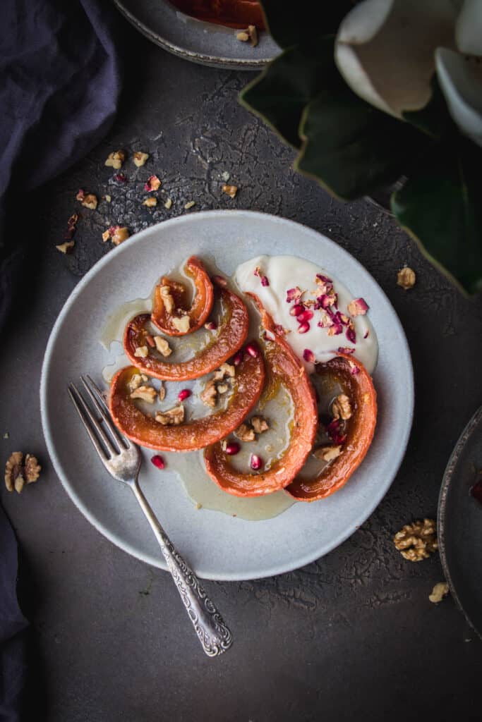 overhead shot of turkish candied pumpkin on a plate with yogurt and pomegranate