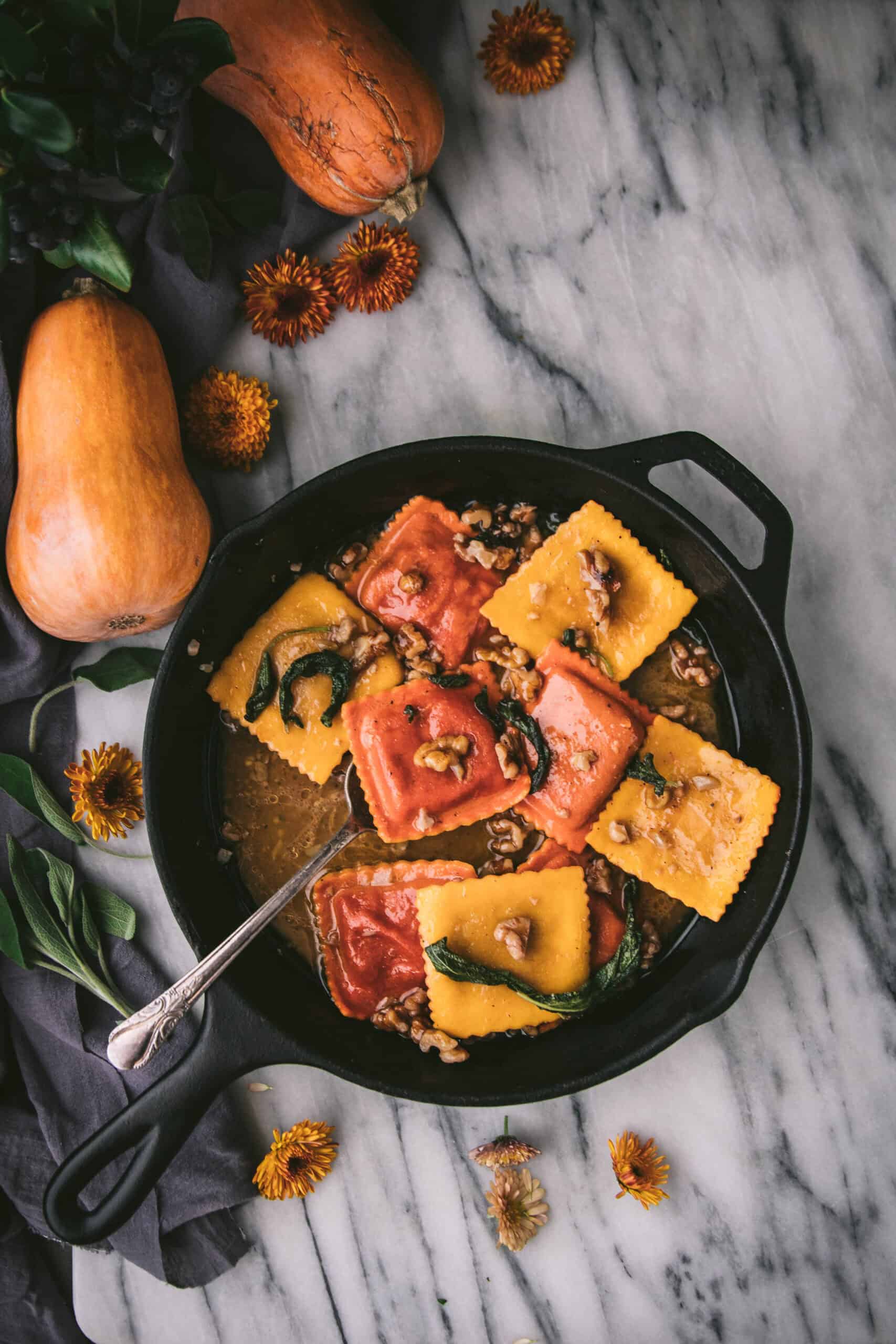 overehead shot of a cast iron skillet with butternut ravioli coated in sage brown butter