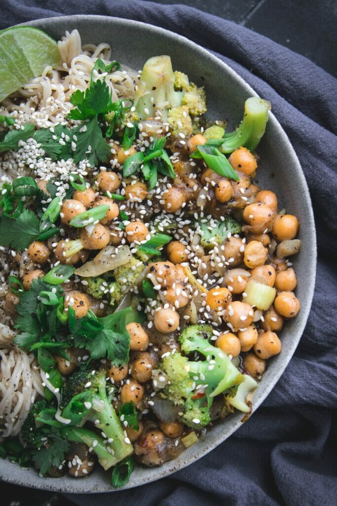 close up of vegan black pepper chickpeas with broccoli and noodles