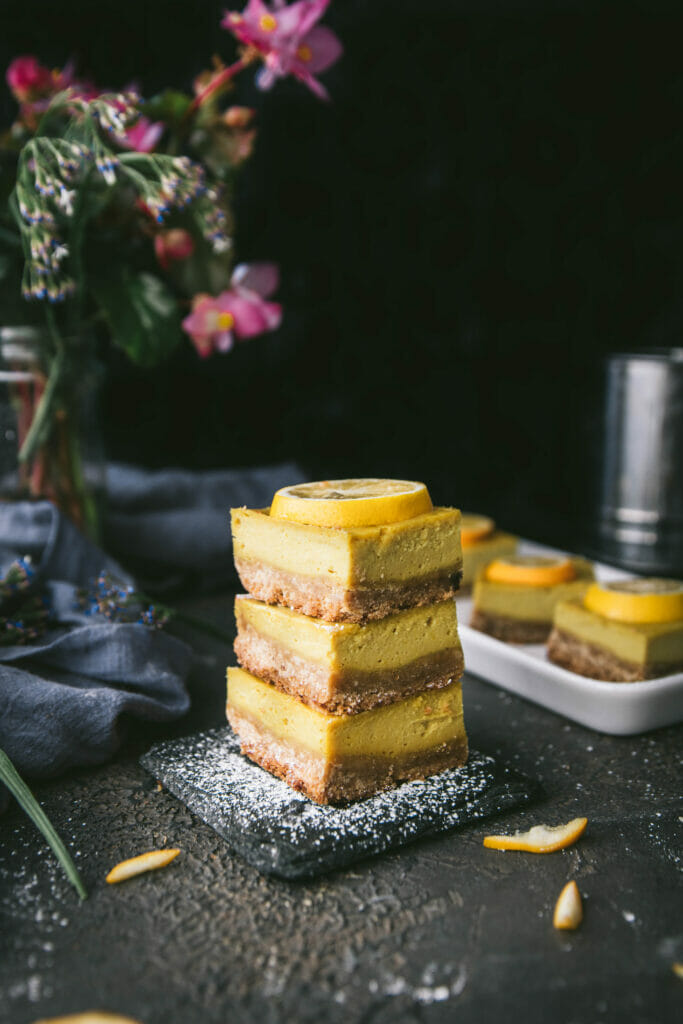 stack of three meyer lemon cheesecake bars on a black table