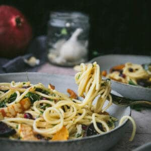 fork with a twirl of vegan garlic spaghetti resting on a plate