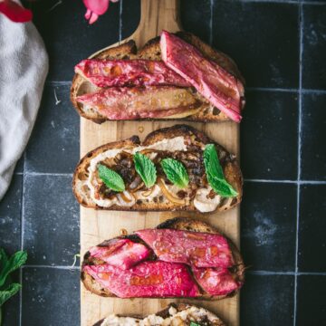 four pieces of toasted bread topped with rhubarb and cashew cheese