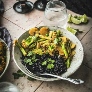 bowl of turmeric cauliflower and peas on a table