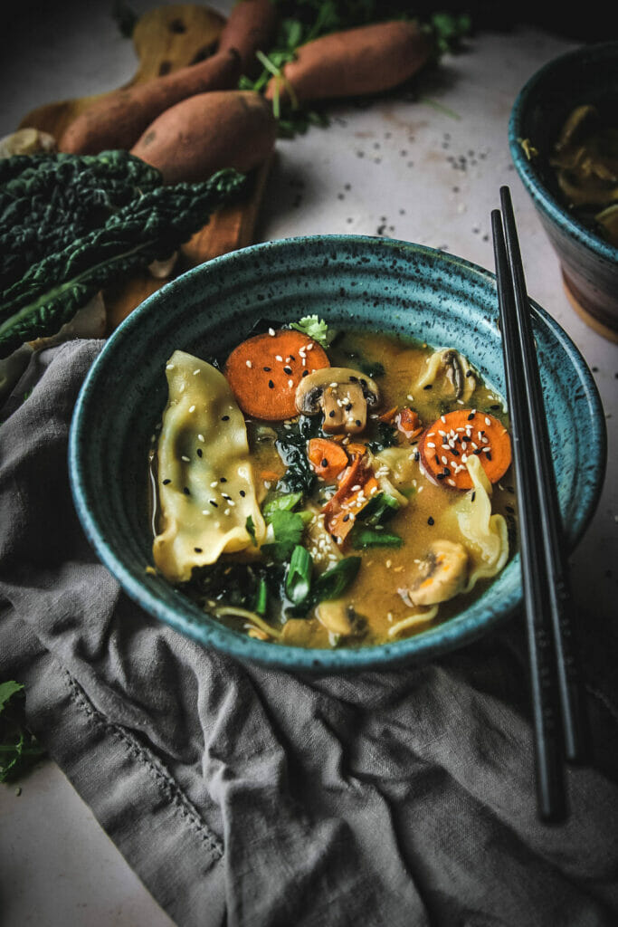 side view of a bowl of vegetable miso dumpling soup