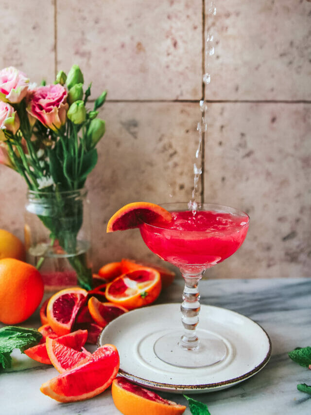 seltzer pouring into a glass of blood orange screwdriver cocktail