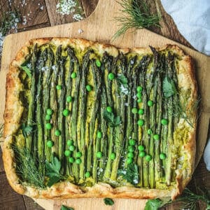 overhead shot of a vegan asparagus ricotta galette on a wooden board