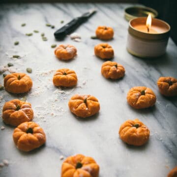 marble board with pumpkin-shaped gnocchi and a candle