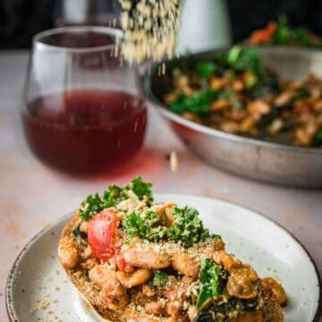 crispy white beans on toast with kale and tomatoes with cashew parmesan